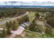 Aerial shot features the home's layout, a three-car garage, driveway, expansive land and white fencing at 10393 Deerfield Rd, Franktown, CO 80116