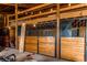 Interior view of the barn, highlighting the stalls with wood accents, and overhead lighting at 10393 Deerfield Rd, Franktown, CO 80116