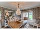 Formal dining room with elegant chandelier, patterned wallpaper, and ample natural light at 10393 Deerfield Rd, Franktown, CO 80116