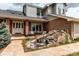 Charming home with a brick facade, well-manicured landscaping, and a lovely rock water feature at 10393 Deerfield Rd, Franktown, CO 80116