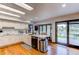Well-lit kitchen with white cabinets, stainless steel dishwasher, and access to the outdoor deck at 10393 Deerfield Rd, Franktown, CO 80116