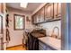 Efficient laundry room with modern washer and dryer, ample cabinet space, and convenient sink area at 10393 Deerfield Rd, Franktown, CO 80116
