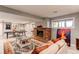 A finished basement living room with a brick fireplace, a ping pong table and built in shelving at 10393 Deerfield Rd, Franktown, CO 80116