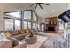 Bright living room with vaulted ceilings, large windows, and a cozy fireplace create an inviting atmosphere at 10393 Deerfield Rd, Franktown, CO 80116