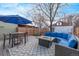 Inviting backyard patio featuring an outdoor seating area, fire pit, and well-maintained wooden deck under a blue umbrella at 3339 Tejon St, Denver, CO 80211