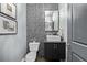 Stylish powder room showcasing geometric tiled accent wall, modern vanity, and decorative mirror at 3339 Tejon St, Denver, CO 80211