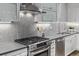 Close up view of stainless steel stove, stylish backsplash, and sleek countertops in the modern kitchen at 3339 Tejon St, Denver, CO 80211