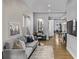 Modern living room with hardwood floors, a plush sofa, and a view into the kitchen offers a stylish and functional living space at 3339 Tejon St, Denver, CO 80211