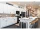 Modern kitchen featuring stainless steel appliances, white cabinets, and a breakfast bar with stylish pendant lighting at 2572 Iola St, Aurora, CO 80010