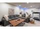 Cozy living space featuring a large gray sectional, rustic coffee table, and workout equipment at 2572 Iola St, Aurora, CO 80010