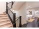 Carpeted staircase with dark wooden banisters leading to the upper level of the home at 2572 Iola St, Aurora, CO 80010