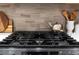 Close-up of a modern stovetop with stylish accessories like a tea kettle and wooden cooking utensils at 2572 Iola St, Aurora, CO 80010