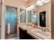 Bathroom featuring double sinks, a large mirror, and a walk-in shower, providing plenty of space at 3375 Starry Night Loop, Castle Rock, CO 80109