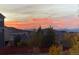 Sunset views over rooftops, mountains, and autumn foliage in a neighborhood at 3375 Starry Night Loop, Castle Rock, CO 80109