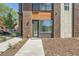 Modern home featuring a stylish front door, brick and wood accents, and a well-maintained walkway at 701 E 24Th Ave, Denver, CO 80205