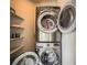 Laundry room with stackable washer and dryer set and storage shelves at 701 E 24Th Ave, Denver, CO 80205