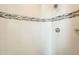 Corner shower featuring white tile, decorative band, and modern fixtures at 701 E 24Th Ave, Denver, CO 80205