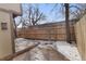 Cozy backyard featuring a wood fence, a deck, and partial snow cover at 12655 W Bayaud Ave # 40, Lakewood, CO 80228