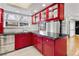 Bright kitchen boasts updated red cabinetry with black countertops and stainless steel sink at 12655 W Bayaud Ave # 40, Lakewood, CO 80228