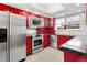 Bright kitchen boasts updated red cabinetry and stainless steel appliances at 12655 W Bayaud Ave # 40, Lakewood, CO 80228