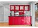 Kitchen island with black countertop and red cabinets, plus glass front upper cabinets at 12655 W Bayaud Ave # 40, Lakewood, CO 80228