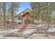 Stunning home featuring a stone facade, exposed timber accents, and a welcoming entryway with rustic wreath at 1662 Gore Dr, Larkspur, CO 80118