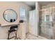 Bathroom with a large shower with glass door, gray tile surround, white cabinets and black counter at 6320 Indian Paintbrush St # 108, Frederick, CO 80530
