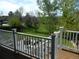 A peaceful backyard view with white railings, a lush lawn, and mature trees, perfect for outdoor enjoyment at 9684 W Long Dr, Littleton, CO 80123