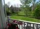 Scenic backyard view framed by a white railing, showing a lush lawn and mature trees, creating a serene setting at 9684 W Long Dr, Littleton, CO 80123