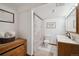 Bright bathroom with a wooden vanity, framed decor, and shower curtain, offering a cozy and functional space at 9684 W Long Dr, Littleton, CO 80123