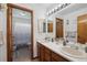 Bathroom with dual vanity sinks, tile floors, and a shower with white shower curtain at 9684 W Long Dr, Littleton, CO 80123