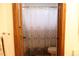 Bright bathroom showcasing a patterned shower curtain, toilet, and dark wood trim at 9684 W Long Dr, Littleton, CO 80123