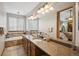 Bright bathroom featuring dual vanities, granite counters, soaking tub and access to main bedroom at 9684 W Long Dr, Littleton, CO 80123
