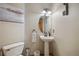 Stylish half bathroom with pedestal sink, decorative mirror and modern fixtures at 9684 W Long Dr, Littleton, CO 80123