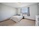 Neutral bedroom featuring a cozy bed, a bright window, and soft neutral carpet at 9684 W Long Dr, Littleton, CO 80123