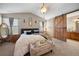 Large primary bedroom with a king bed, side tables, and a barn door leading to the bathroom at 9684 W Long Dr, Littleton, CO 80123
