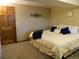 Bedroom with carpet and trim, and a bed with white comforter and blue pillows and blanket at 9684 W Long Dr, Littleton, CO 80123