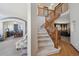Entryway featuring a staircase with wooden banister and views into the living and dining areas at 9684 W Long Dr, Littleton, CO 80123