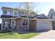 Charming two-story home with a stone facade, well-manicured lawn, and a two-car garage at 9684 W Long Dr, Littleton, CO 80123