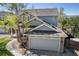 Home featuring stone accents, attached two-car garage, solar panels, and mature trees at 9684 W Long Dr, Littleton, CO 80123