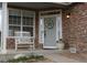 Inviting front porch with a rocking chair, decorative wreath, and potted flowers at 9684 W Long Dr, Littleton, CO 80123