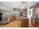 Well-lit kitchen featuring a center island, stainless steel appliances and wooden cabinets at 9684 W Long Dr, Littleton, CO 80123