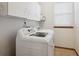 Functional laundry room equipped with washer, dryer and storage cabinets at 9684 W Long Dr, Littleton, CO 80123