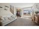 Bright and spacious living room with neutral paint, large windows, and open access to front door at 9684 W Long Dr, Littleton, CO 80123