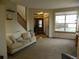 Bright living room featuring a comfortable sofa, large window, and a glimpse of the foyer at 9684 W Long Dr, Littleton, CO 80123