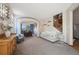 Open-concept living room with dining area, stylish furniture, and a staircase at 9684 W Long Dr, Littleton, CO 80123