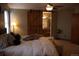 Comfortable bedroom featuring a barn door leading to an ensuite bathroom, neutral paint, and plush carpet at 9684 W Long Dr, Littleton, CO 80123
