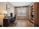 Cozy home office with a computer desk, wood floors, and bright natural light from the window at 9684 W Long Dr, Littleton, CO 80123