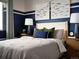 Stylish bedroom featuring a blue accent wall, a comfortable bed, and modern decor at 4090 Estrella St, Brighton, CO 80601