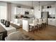Bright eat-in kitchen features white cabinets, stainless steel appliances, and an island with bar stool seating at 4090 Estrella St, Brighton, CO 80601